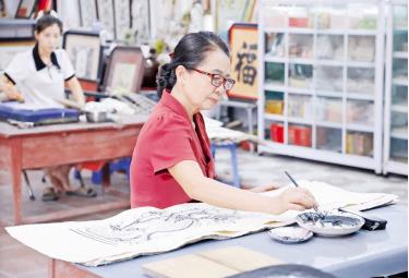 Nghệ nhân Ưu tú Nguyễn Thị Oanh tại phòng vẽ tranh của gia đình.