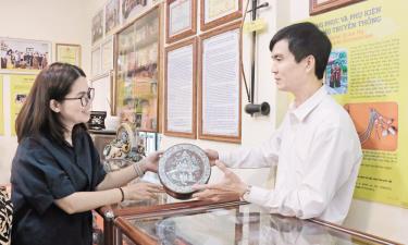 Liền anh Dương Đức Thắng giới thiệu chiếc cơi đựng trầu của nghệ nhân quan họ Nguyễn Thị Hạp.