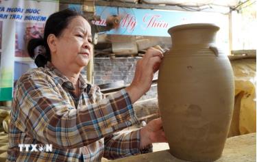 Nghệ nhân tạo hình sản phẩm gốm truyền thống từ nguyên liệu đất sét. (Ảnh: Lê Phước Ngọc/TTXVN)